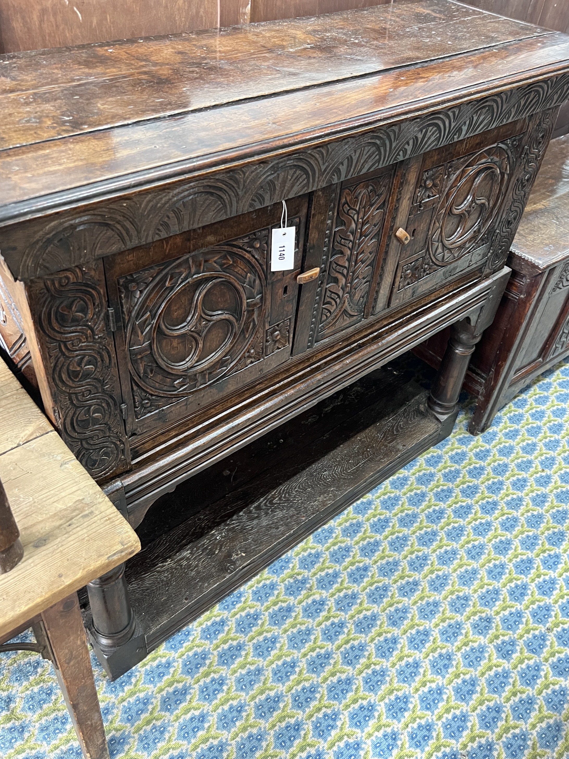 A 17th century and later carved oak potboard cupboard on stand, width 123cm, depth 43cm, height 111cm